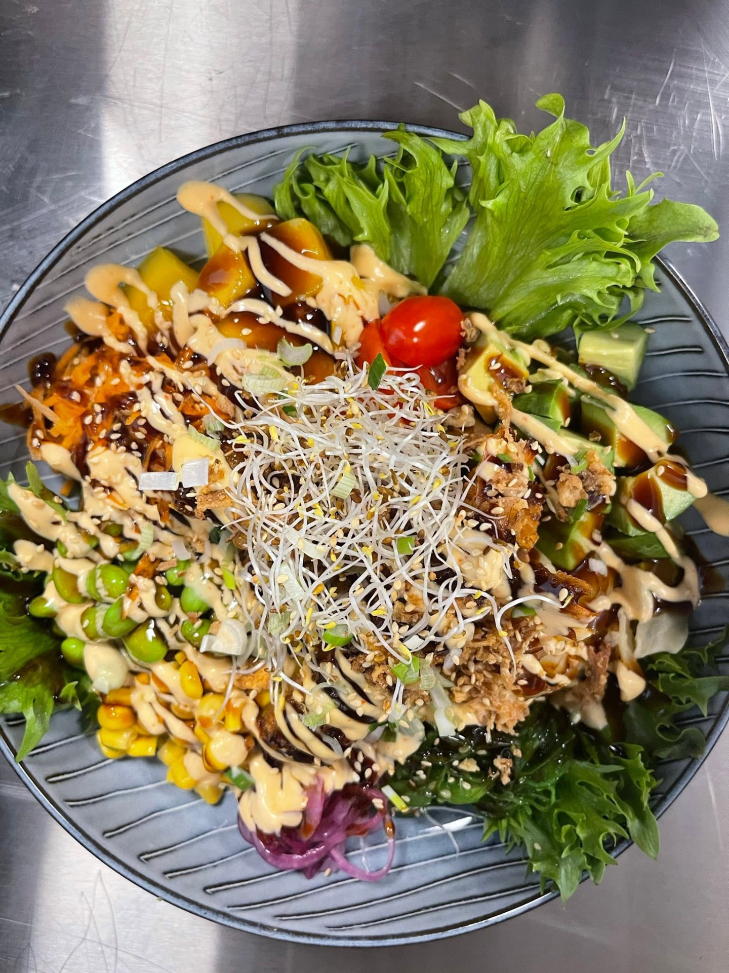 Poké bowl fotad uppifrån på grå tallrik
